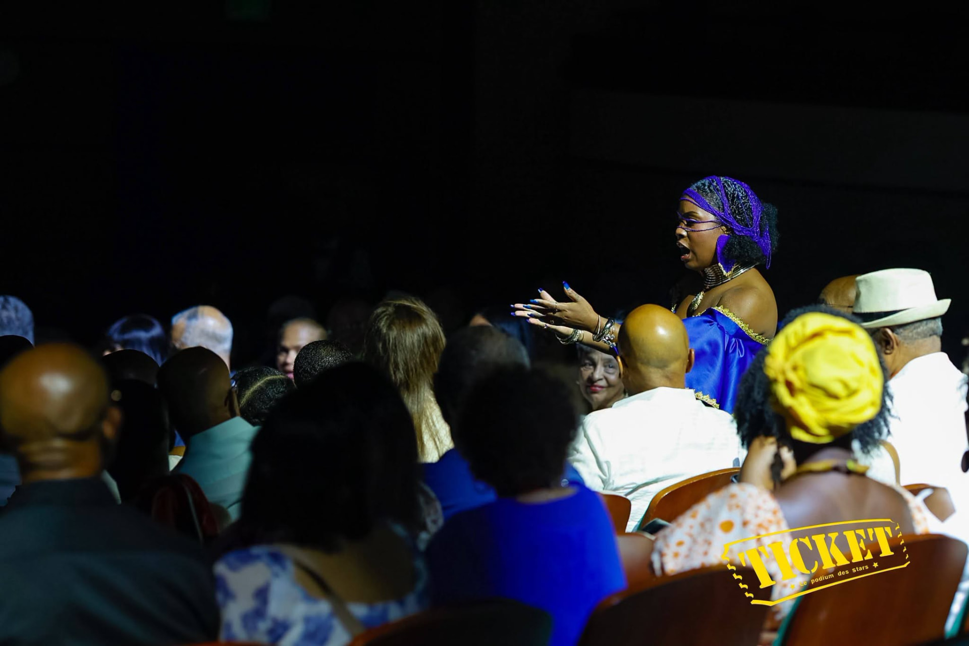 A performer singing among the audience in the aisles